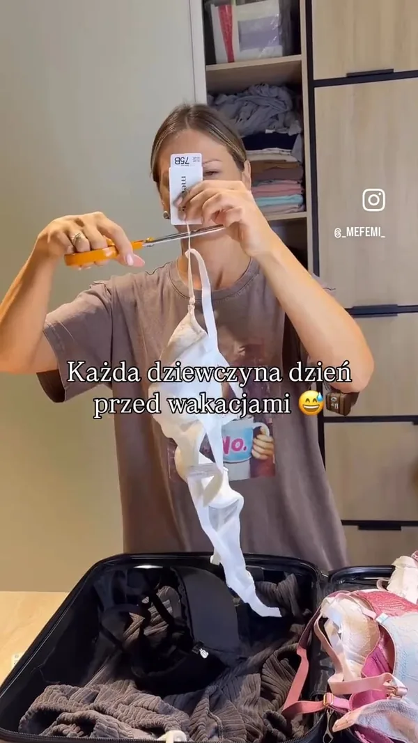 Kadr z rolki: odcinanie metki od nowej bielizny nad otwartą walizką